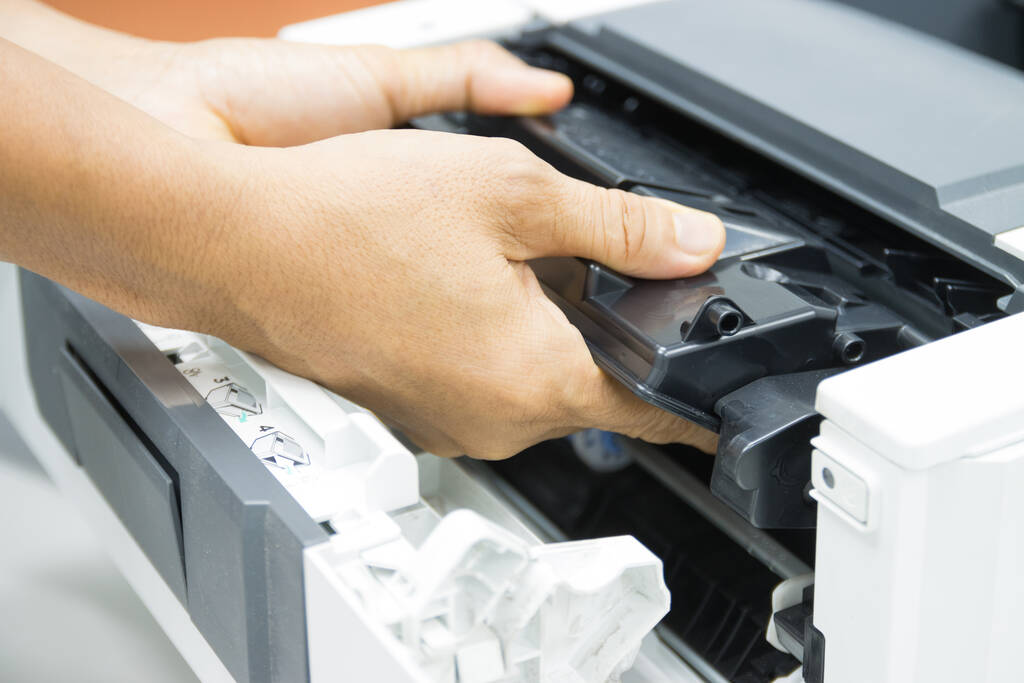 Technicians replacing toner in laser printer